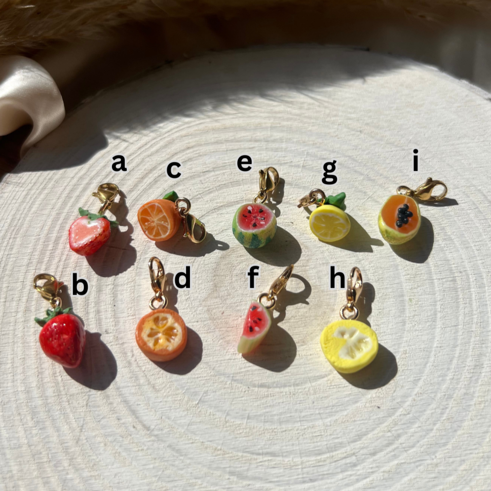 Set of colorful fruit-shaped keychains on a textured surface